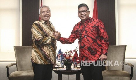 Sekretaris Jenderal DPP PDIP Hasto Kristiyanto (kanan) berjabat tangan dengan Wakil Ketua Dewan Pembina Partai Demokrat Agus Hermanto (kiri) di DPP PDIP, Jakarta, Jumat (13/7).