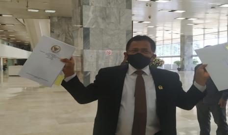 Sekretaris Jenderal (Sekjen) DPR Indra Iskandar menunjukan naskah final Undang-Undang Cipta Kerja ke media sebelum menuju Kantor Sekretariat Negara untum diserahkan ke Pemerintah, Jakarta,  Rabu (14/10). 