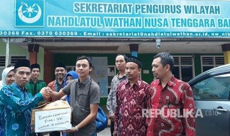 Sekretaris Pengurus Wilayah Nahdlatul Wathan (PWNW) Irzani menyerahkan bantuan untuk Rohingnya melalui Perwakilan Republika Muhammad Nursyamsyi di Kantor PWNW, Mataram, NTB, Rabu (4/10). 