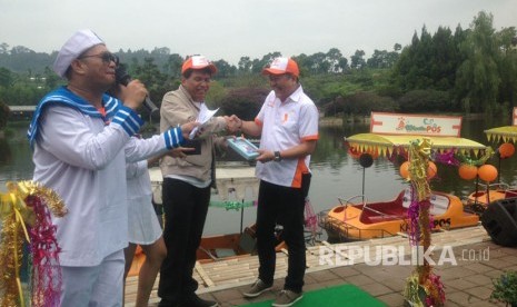 Sekretaris Perusahaan PT Pos Indonesia, Hairul Syafiudin serah terima piagam dengan Owner Floating Market Perry Tristianto di Kawasan Floating Market Lembang, Ahad (26/3). 