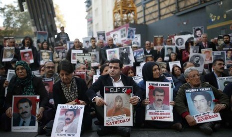 Selahattin Demirtas (tengah depan), ketua bersama Partai Demokrasi Rakyat (HDP) pro Kurdi Turki, menghadiri aksi duduk di Lapangan Galatasaray, Istanbul, Turki, Sabtu (14/11). 