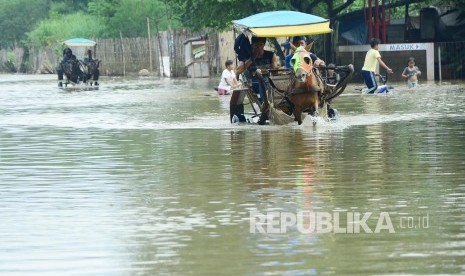 Selain perahu, untuk melewati jalan yang terendam banjir luapan Sungai Citarum, masyarakat menggunakan delman seperti di Cieunteung, Kecamatan Baleendah, Kabupaten Bandung, Senin (31/10). 