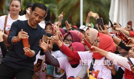 Senam Bersama Srikandi Jokowi-Maruf Amin. Calon Presiden petahana Joko Widodo (kiri) melayani permintaan swafoto pendukungnya saat menghadiri Senam Bersama Srikandi Jokowi-Maruf Amin di Jakabaring Sport City, Palembang, Sumatera Selatan, Sabtu (9/3/2019). 