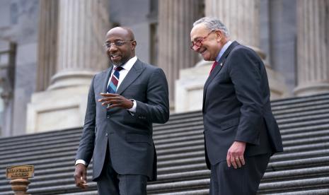 Senator Raphael Warnock, D-Ga., kiri, disambut kembali ke Capitol oleh Pemimpin Mayoritas Senat Chuck Schumer, D-N.Y., setelah Warnock mengalahkan penantang dari Partai Republik Herschel Walker dalam pemilihan putaran kedua di Georgia tadi malam, di Washington, Rabu , 7 Desember 2022.