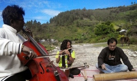 Seniman Aceh memainkan musik di kebun kopi Bukit Mendale (foto atas) dan Bener Meriah, Aceh Tengah (foto bawah).