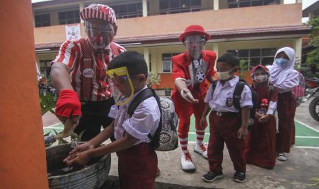 Seniman Aku Badut Indonesia (ABI) memberikan edukasi mencuci tangan kepada siswa di SDN 03 Citayam, Kabupaten Bogor, Jawa Barat, Senin (6/9/2021). Kegiatan aksi edukasi tersebut tentang protokol kesehatan serta membagikan masker kepada anak-anak sekolah yang menggelar Pembelajaran Tatap Muka (PTM).