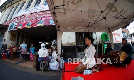 Seniman dari Dinas Kebudayaan (Disbud) Kota Solo menghibur pengunjung dan pedagang di Pasar Gede Solo, Jawa Tengah, Kamis (15/4/2021). Pemerintah Kota Solo menghadirkan hiburan tradisional Siteran tersebut untuk meningkatkan jumlah kunjungan pembeli dan menarik wisatawan di Pasar Gede Solo. 