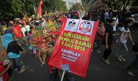 Seniman dari Republik Aeng-Aeng mengenakan kostum unik ketika mengkampanyekan pemilu damai pada Car Free Day di Solo, Jawa Tengah, Ahad (8/6). 