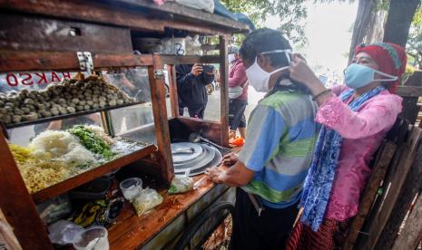 Warga menggunakan masker guna memutus mata rantai penyebaran Covid-19 