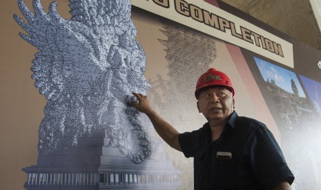 Seniman patung Nyoman Nuarta menjelaskan tahapan pemasangan bagian-bagian patung Garuda Wisnu Kencana di Bukit Jimbaran, Bali, Rabu (25/10).