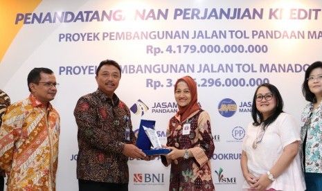 Senior Vice President Corporate Banking PT Bank Central Asia (BCA) Tbk Yuli Melati (ketiga kanan) bersama Senior Vice President Corporate Finance Susiana Santoso (kedua kanan) dan Senior Vice President Corporate Branch Dhejani Surjadi (kanan) menyerahkan cinderamata kepada Direktur Utama PT Jasamarga Pandaan Malang (JPM) Mohamad Agus Setiawan (ketiga kiri) disaksikan oleh Direktur Utama PT Jasamarga Manado Bitung (JMB) George IMP Manurung (kiri), Direktur Keuangan PT Jasa Marga Donny Arsal seusai penandatanganan dua Perjanjian Kredit Sindikasi di Jakarta, Jumat (13/10).