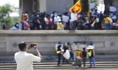 Seorang agen keamanan pemerintah berpakaian preman memotret warga Sri Lanka yang memprotes menuntut presiden Gotabaya Rajapaksa mengundurkan diri di Kolombo, Sri Lanka, Senin, 4 April 2022. Presiden Sri Lanka pada hari Senin mengundang semua partai politik yang diwakili di Parlemen untuk menerima kementerian setelah Kabinetnya mengundurkan diri di tengah protes publik atas krisis ekonomi terburuk di negara itu dalam memori yang telah menyebabkan kekurangan makanan, bahan bakar dan obat-obatan.