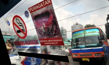 Aktivis Koalisi Warga Untuk Jakarta Bebas asap Rokok (Smoke Free Jakarta) menempelkan stiker penanda larangan merokok di angkutan umum di Terminal Senen Jakarta, Selasa (21/5).    (Republika/Prayogi)