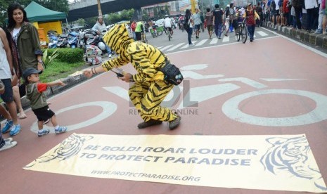  Seorang aktivis membagikan topeng harimau dalam aksi kampanye penyelamatan hutan Indonesia, di Car Free Day (CFD), Jl Ir H Djuanda, Kota Bandung.  (Ilustrasi) 