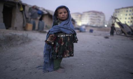 Seorang anak berdiri di luar rumahnya di lingkungan tempat banyak pengungsi internal telah tinggal selama bertahun-tahun, di Kabul, Afghanistan, Selasa, 7 Desember 2021.