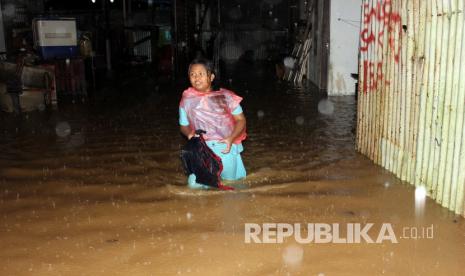 Seorang anak berjalan melintasi banjir di permukiman warga di Kota Sorong, Papua Barat, Kaamis (16/7/2020). Hujan dengan intensitas tinggi di kawasan tersebut mengakibatkan banjir dan longsor dengan data sementara dari Badan Penanggulangan Bencana Daerah (BPBD) setempat, dua warga orang meninggal dunia akibat tertimbun longsor dan seorang warga meninggal karena tersengat arus listrik. 