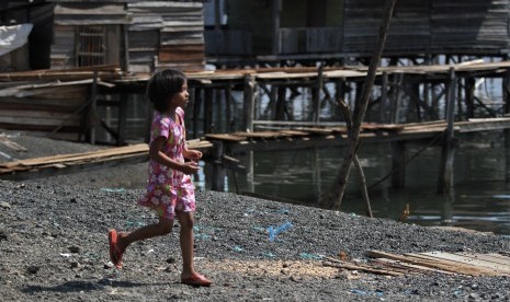 Seorang anak berlari diatas hambaran limbah butiran pembakaran Ore Nikel milik salah satu perusahaan pertambangan yang dibuang di pesisir laut di Kecamatan Pomalaa, Kabupaten Kolaka, Sulawesi Tenggara, Sabtu (18/5/2019).