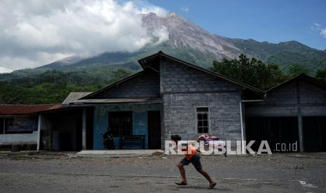 Sleman Siapkan 12 Barak Pengungsian Bagi Warga Merapi. Seorang anak bermain dengan latar belakang Gunung Merapi di kawasan Kinahrejo, Cangkringan, Sleman, D.I Yogyakarta, Rabu (18/11/2020). Berdasarkan data pengamatan Balai Penyelidikan dan Pengembangan Teknologi Kebencanaan Geologi (BPPTKG) Yogyakarta pada Rabu (18/11) pukul 06.00 WIB - 12.00 WIB Gunung Merapi mengalami 16 kali guguran serta 7 kali gempa vulkanik dangkal. 