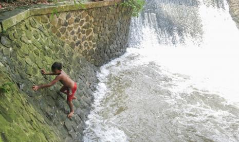 Seorang anak bermain di aliran Sungai Pesanggrahan, Bojonggede, Kabupaten Bogor, Jawa Barat, Jumat (22/10/2021). Terbatasnya lahan bermain menyebabkan sejumlah anak melakukan aktivitas bermain di tempat itu walaupun dapat membahayakan jiwa mereka.