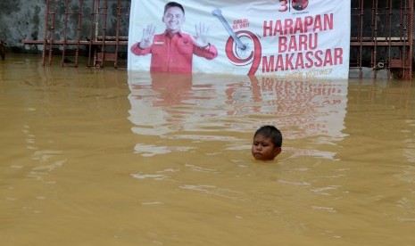 Seorang anak bermain di lokasi banjir di Perumahan Bumi Bung Permai, Makassar, Sulawesi Selatan, Kamis (24/01/2019).