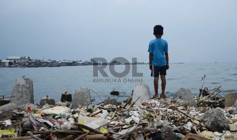 Seorang anak bermain di tumpukan sampah yang berada di Pesisir Pantai, Jakarta Utara, Kamis (29/1).(Republika/Raisan Al Farisi)