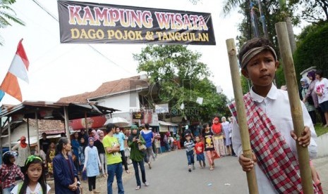   Seorang anak bermain egrang di 'Kampung Wisata Kreatif' oleh Bandung Creative City Forum (BCCF), Komunitas Taboo, dan Pemkot Bandung, di kawasan Dago Pojok dan Tanggulan, Bandung, Ahad (27/10). (Republika/Edi Yusuf)