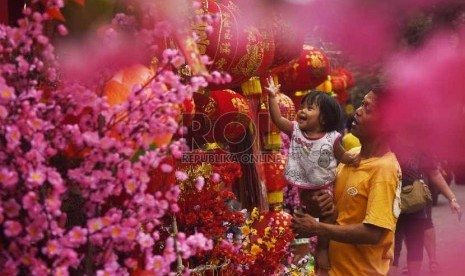 Seorang anak bermain lampion yang dijual di kawasan Petak Sembilan, Jakarta Barat, Selasa (27/1). 