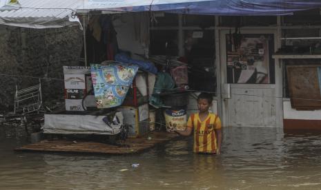 Seorang anak bermain pancing di depan rumah yang terendam banjir di Cimanggis, Depok, Jawa Barat.