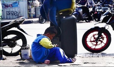 Seorang anak berpakaian badut mengoperasikan gawainya di tengah keramaian Jl Soekarno Hatta Bandung. Diperlukan kebijaksanaan orang tua dalam memberikan akses internet yang aman kepada anak-anaknya. Literasi Digital Langkah Awal Cegah Anak dari Kekerasan Daring