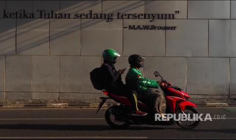 Seorang penumpang ojek online mengoperasikan gawainya saat sepeda motor melaju di jalanan Kota Bandung. Menteri Koordinator Bidang Perekonomian Airlangga Hartarto mengatakan digitalisasi merupakan salah satu sarana untuk mengakselerasi transformasi menuju ekonomi baru. 