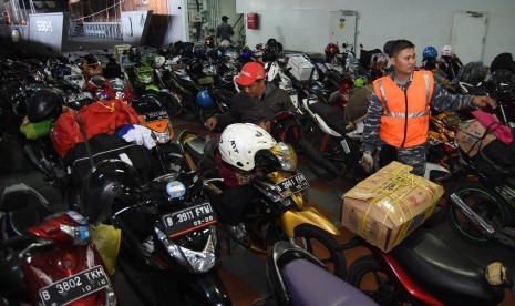 Seorang anak buah kapal (ABK) mengatur sepeda motor pemudik di geladak KRI Makassar-590 yang bersandar di Dermaga Gapura Surya, Tanjung Perak, Surabaya, Jawa Timur, Selasa (21/7).