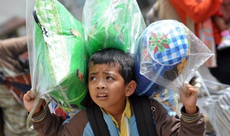 Seorang anak dari peserta transmigrasi asal DI Yogyakarta membopong barang bawaan, sesaat setelah turun dari KM Leuser jurusan Semarang-Pontianak, di Pelabuhan Dwikora, Pontianak, Kalbar