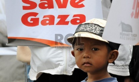 Seorang anak di tengah massa demonstran dari Hizbut Tahrir Indonesia (HTI) yang berunjuk rasa di depan Kedubes Amerika Serikat, Jakarta, Senin (19/11). (Republika/Aditya Pradana Putra)