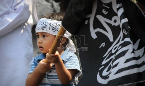   Seorang anak ikut bergabung dengan aksi unjuk rasa Hizbut Tahrir Indonesia yang mengutuk pembuatan film yang menghina Nabi Muhammad SAW di depan Kedubes Amerika Serikat, Jakarta, Jumat (14/9).    (Aditya Pradana Putra/Republika)