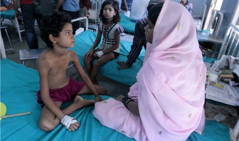 Seorang anak (kiri) ditemani ibunya menjalani perawatan di sebuah rumah sakit setelah mengalami keracunan makanan di Patna, Bihar, India. 