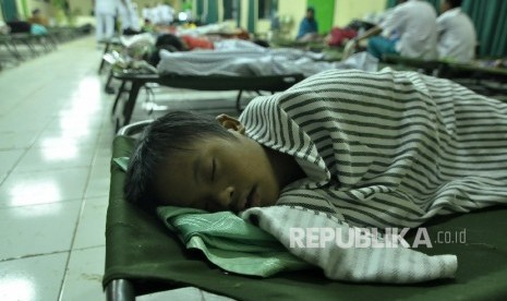 Seorang anak korban banjir tertidur dilokasi pengungsian di Korem 062/Tarunanegara, Jl Bratayuda, Kabupaten Garut, Kamis (22/9) Dini hari. 