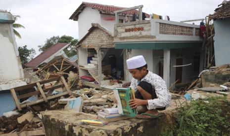   Bolehkah Membakar Mushaf Alquran yang Sudah Rusak?. Foto ilustrasi: Seorang anak laki-laki memilah kitab suci Alquran yang dia selamatkan dari bawah reruntuhan di reruntuhan Pesantren Al Buroq yang rusak parah saat gempa Senin, di Cianjur, Jawa Barat, Indonesia, Rabu, 23 November 2022. Lebih banyak penyelamat dan relawan dikerahkan Rabu di daerah yang hancur di pulau utama Indonesia Jawa untuk mencari korban tewas dan hilang akibat gempa bumi yang menewaskan ratusan orang. 