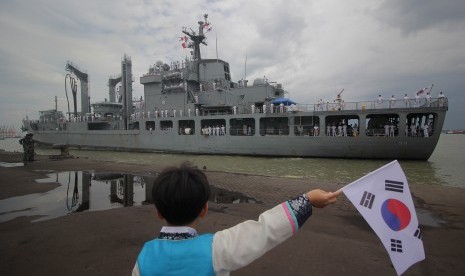 Seorang anak melambaikan bendera menyambut kedatangan kapal perang Korsel Hwacheon (AOE-59) saat bersandar di Dermaga Jamrud Utara, Pelabuhan Tanjung Perak, Surabaya, Jawa Timur, Ahad (5/11).