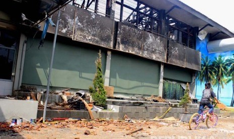  Seorang anak melewati sisa bangunan akibat kebakaran di  Lembaga Pemasyarakatan Kelas IIA Banceuy, Kota Bandung, Ahad (24/4). (Republika/Dede Lukman Hakim)