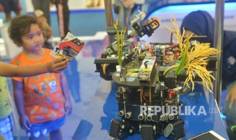 Seorang anak melihat robot penanam padi dalam Ritech Expo 2019 yaitu rangkaian peringatan Hari Kebangkitan Teknologi Nasional (Hakteknas) ke-24 di Denpasar, Bali, Ahad (25/8/2019).