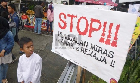 Seorang anak melihat sebuah poster antimiras pada aksi Gerakan Anti Miras (minuman keras) Nasional di Car Free Day (CFD) kawasan Dago, Bandung, Ahad (19/1). (Republika/Edi Yusuf)