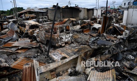 Seorang anak melintas di antara sisa-sisa kebakaran yang menghanguskan sejumlah pertokoan dan rumah warga di Entrop, Kota Jayapura, Papua, Ahad (1/9/2019).