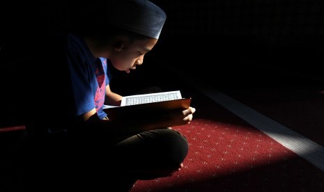 Seorang anak membaca Alquran (ilustrasi)