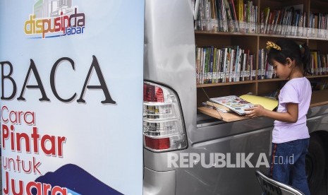 Seorang anak membaca buku di perpustakaan keliling pada acara Festival Literasi 2019 di Halaman Gedung Sate, Kota Bandung, Sabtu (20/4).