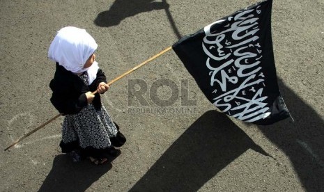  Seorang anak memegang bendera saat aksi unjuk rasa menolak RUU Ormas di depan komplek Parlemen, Jakarta, Jumat (5/4).  (Republika/Yasin Habibi)