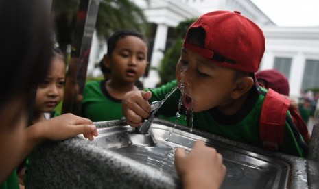 Seorang anak meminum air secara langsung dari kran milik PT PAM Lyonnaise Jaya (Palyja) di Museum Nasional, Jakarta, Rabu (13/2/2019).