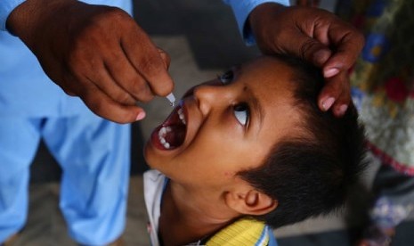 Seorang anak mendapatkan vaksin polio dari petugas kesehatan di Karachi, Pakistan