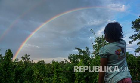 Mengenal Al Qarafi, Ilmuwan Muslim yang Menjelaskan Pelangi. Foto: Seorang anak mengamati fenomena alam pelangi yang terlihat di Cepokokuning, Kabupaten Batang, Jawa Tengah, Sabtu (11/4/2020). Fenomena alam munculnya pelangi tersebut terjadi karena proses pembiasan sinar matahari ke tetesan air hujan sehingga menimbulkan bermacam deretan warna. 