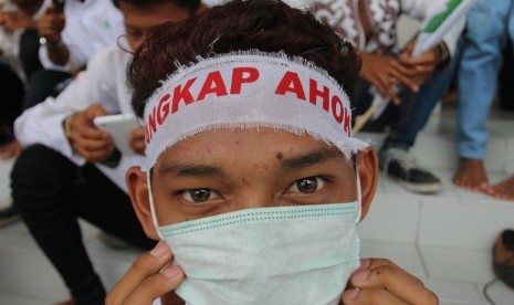 Seorang anak menggunakan ikat kepala saat ikut berunjuk rasa mengecam Gubernur DKI Jakarta Basuki Tjahaja Purnama atau Ahok di Medan, Sumatra Utara, Jumat (14/10). 