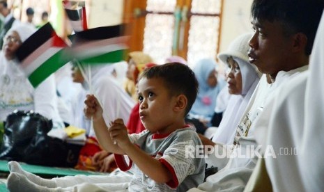 Seorang anak mengibarkan bendera Palestina pada Tabligh Akbar Keluarga Cinta Al Aqsha dalam rangka Isra Mi'raj 1437 H oleh Komite Nasional untuk Rakyat Palestina (KNRP), di Masjid Raya, Kota Bandung, Ahad (15/5). (Republika/Edi Yusuf)